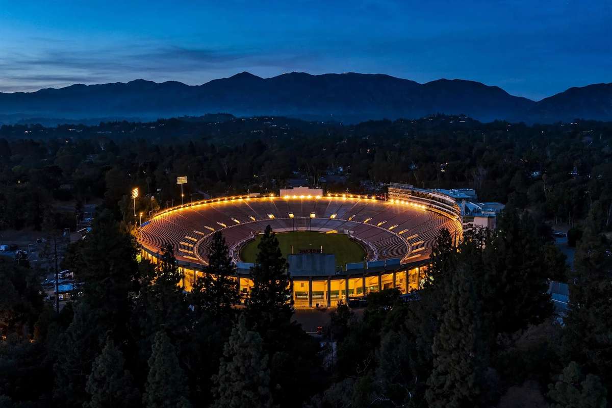 Rose Bowl stadium at dusk with the San Gabriel Mountains behind